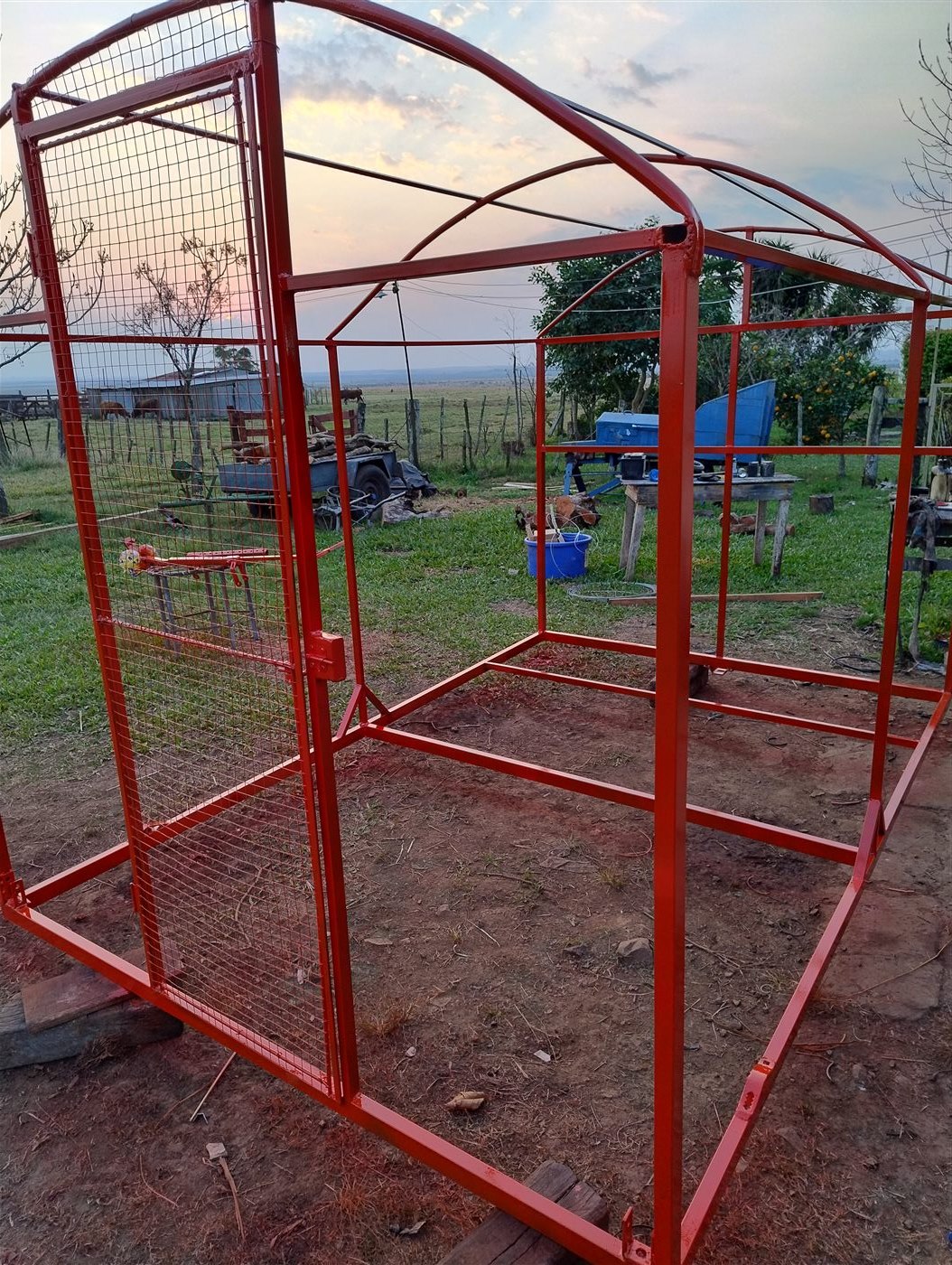 Estrutura de metal ainda sem cobertura, em construção, ao lado de um deque de madeira, com ferramentas espalhadas no chão